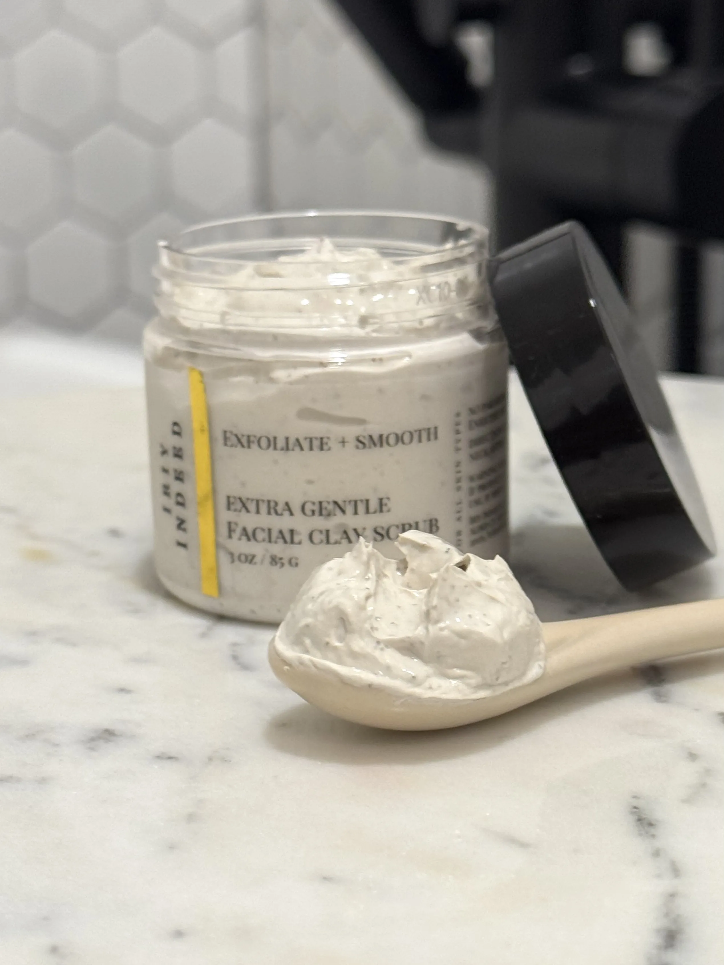 Image of open jar of face scrub with full of scrub spoon in front