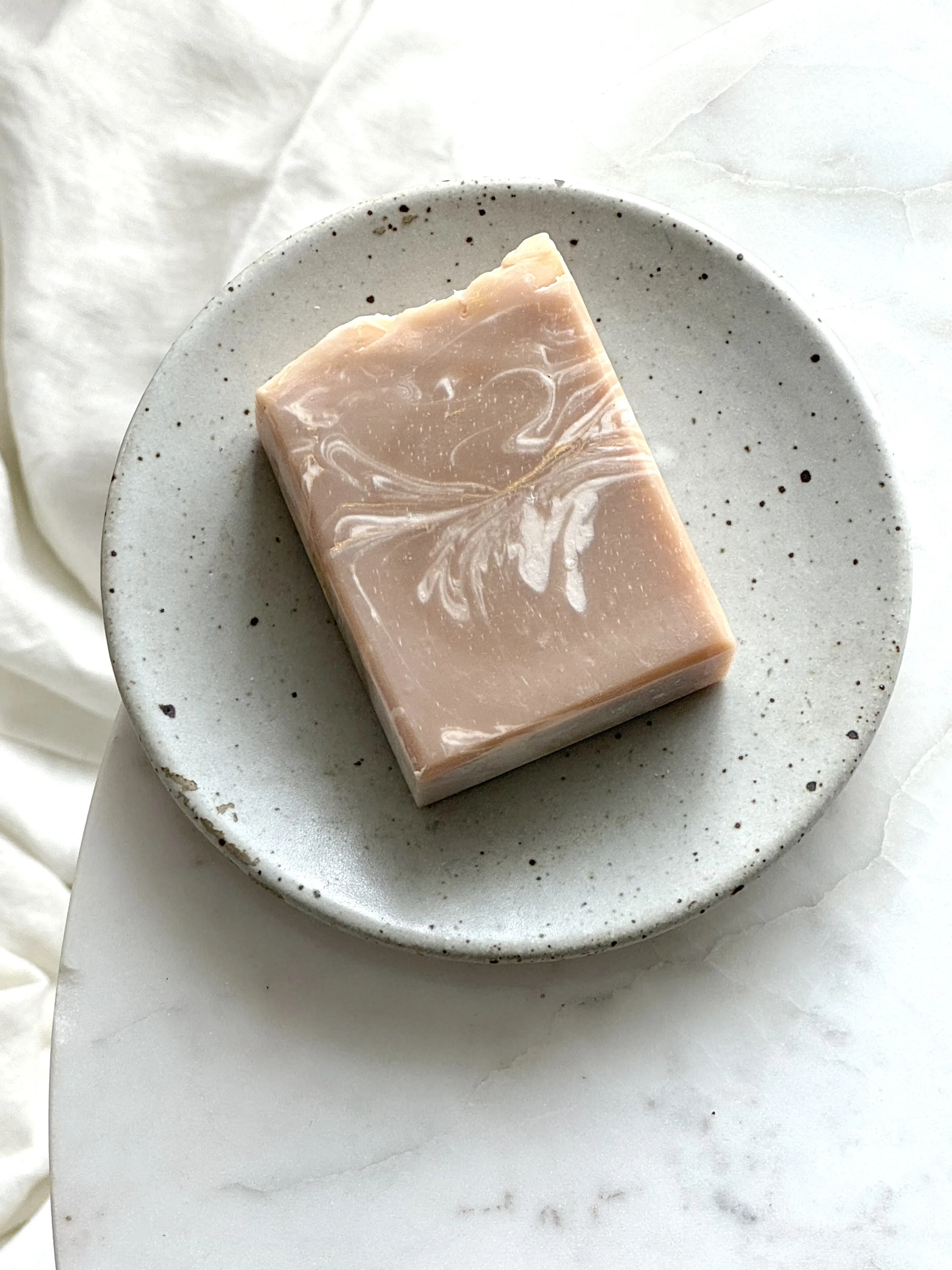 a brown bar soap on grey soap dish