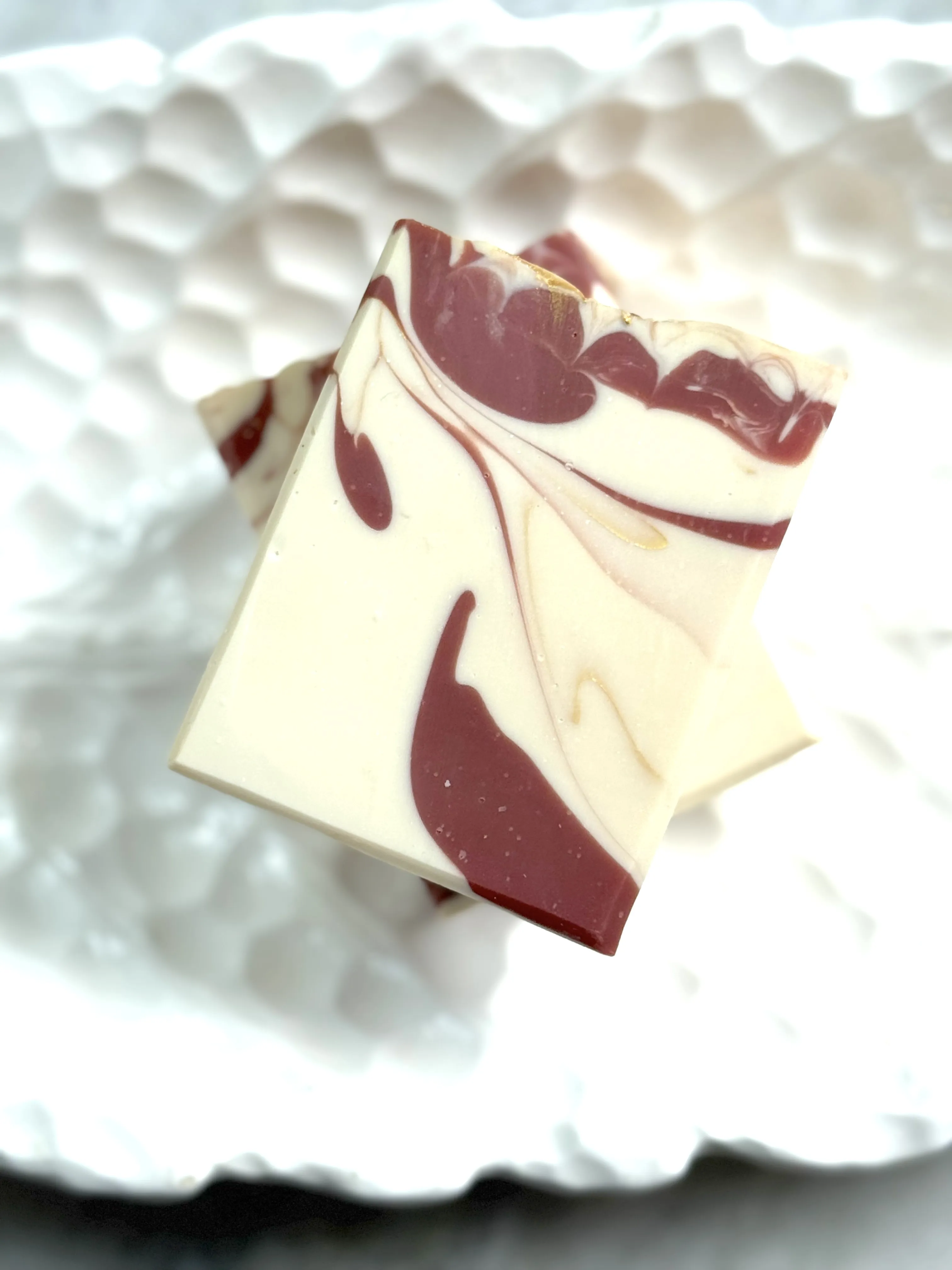 Image of white bar soap with burgundy & gold swirls